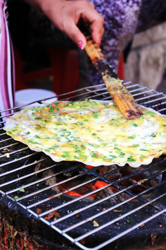<strong>Bánh tráng nướng: </strong>Bánh tráng nướng hay pizza kiểu Việt là một trong những món ngon phổ biến nhất tại Đà Lạt. Giá rẻ, ngon, lại hợp với trời lạnh, miếng bánh tráng nướng mỡ hành, trứng cút, thịt băm, tép rang, tương ớt bên bếp than hồng luôn là món ngon nằm trong danh sách những món không thể bỏ qua của nhiều bạn trẻ.