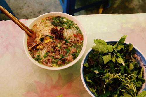 Bún ốc Hàng Chai: Bún ăn theo kiểu chan nước dùng nóng vào bát, có thêm vài cọng hành lá, mấy miếng cà chua… kèm rau sống thơm ngọt lại mát. Nước dùng trong vắt, có phần chua hơn so với bún ốc khác nhưng vẫn rất thanh, đậm đà và vừa miệng, tạo nên hương vị quyến rũ khó cưỡng lại. Một tô bún ốc ở phố Hàng Chai được bán 30.000 đồng. Ảnh: Phong Vinh.