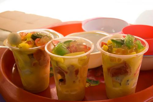 Hoa quả dầm: Hoa quả dầm là món thanh nhiệt yêu thích của giới trẻ Hà Nội. Có nhiều cách làm món này, nhưng điểm chung là đều gồm các loại hoa quả phổ biến như dưa hấu, thanh long, mít, nhãn, xoài, đu đủ... Tất cả được thái miếng nhỏ vừa ăn, cho vào cốc, sau đó thêm chút nước siro, ít hạt trân châu, vài miếng thạch rau câu và sữa đặc. Hoa quả dầm được bán nhiều nhất ở phố Tô Tịch với giá 20.000 đồng một ly. Ảnh: Diệu Huyền.