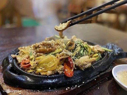 Lợn bản nướng đế gang  Lợn ở miền núi được đồng bào dân tộc nuôi thả và cho ăn ngô, khoai, sắn nên thịt săn chắc, ngọt, da dày. Ở các nhà hàng, loại thịt này thường được chế biến bằng cách quay cả con, nướng ống tre... Ngoài ra, du khách có thể thử lợn nướng đế gang. Sau khi sơ chế và tẩm ướp, thịt sẽ được đặt lên gang và nướng trực tiếp trên bếp lửa với hành tây, hành lá, sả, ớt. Vì vậy khi mang ra bàn, món ăn vẫn giữ nguyên được độ nóng, tỏa khói nghi ngút và phần thịt sát dưới gang cháy giòn. Các nhà hàng thường phục vụ thêm nước chấm ớt xanh. Mỗi suất có giá từ 200.000 đến 250.000 đồng, phục vụ trong các nhà hàng ở đường Xuân Viên và Lương Định Của.