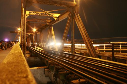 Những buổi tối, cây cầu hơn 100 tuổi Long Biên lại nhộn nhịp những bạn trẻ thong dong tản bộ, tạm xa dần ánh sáng thành thị và ngắm nhìn màn đêm buông. Âm thanh của cuộc sống vang lên với tiếng còi tàu hỏa, tiếng những vòng quay xe đạp của những người buôn bán từ khắp nơi trở về nhà sau ngày làm lụng vất vả. Bạn có thể sà vào một hàng ngô khoai nướng mới dọn hàng để tạm quên đi cái giá rét của mùa đông Hà Nội. Ảnh: Minh Đức