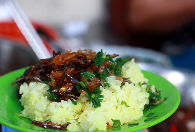 Một đĩa xôi ngon đến từ sự kết hợp giữa vị mằn mặn của cá cơm kho, mùi thơm của xôi nếp dẻo và một chút vị béo của mỡ hành rưới trên mặt. Chỉ với 10.000 đồng, bạn có thể khởi đầu ngày mới với một đĩa xôi cá cơm ngon lành và chắc bụng.