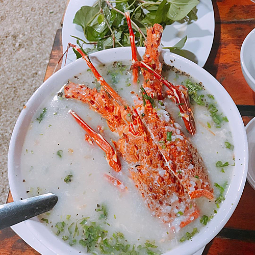 Cháo tôm hùm  Những con tôm lớn, nhiều thịt, chắc và ngọt thường được chế biến thành nhiều món như hấp, nướng hay rim, nấu canh chua. Trong đó, cháo tôm hùm mang lại cho thực khách trải nghiệm khác về vị ngọt của hải sản và dễ ăn. Bạn sẽ cảm nhận được mùi tía tô, hành, tiêu quyện với thịt tôm dai, ngọt đậm đà. Ảnh: Tuyết Minh.