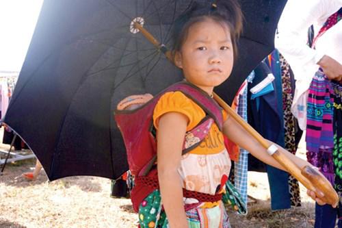 Địu em theo mẹ đi chợ.