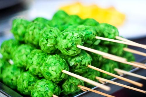 Những viên chả cốm có màu xanh tươi, được bàn tay khéo léo của người bán nặn tròn. Khi khách hàng chọn món, cô bán hàng nhanh tay bắc chảo, đưa xiên cốm vào rán. Món ăn có vị bùi của cốm, quyện với vị ngậy và chút cay của tương ớt khi ăn kèm. Thưởng thức lúc còn nóng, viên cốm giữ được vị mềm và dẻo vốn có.