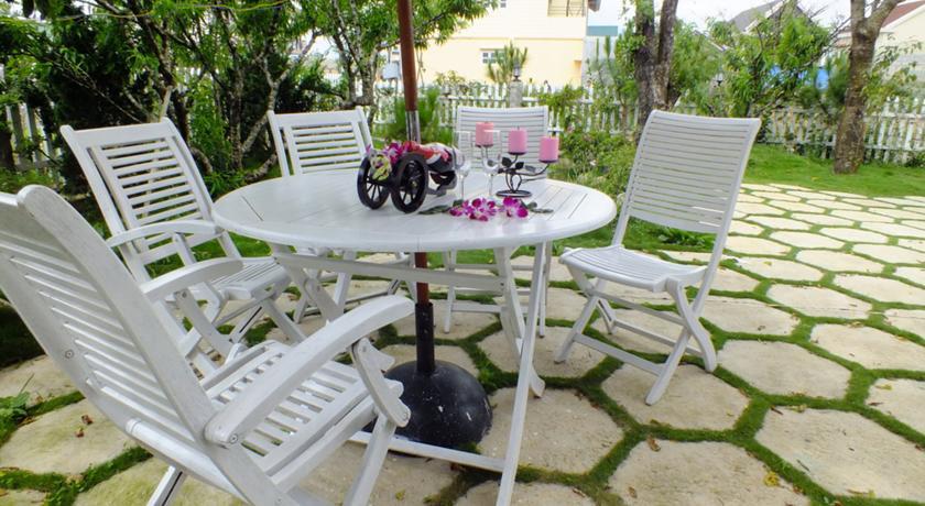 Bộ bàn ghế xinh xắn đặt trong sân khách sạn, nơi để du khách nghỉ chân ngắm cảnh.