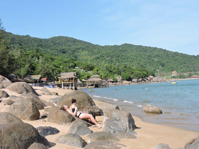 Nằm phơi nắng trên đá, thả hồn trong gió biển là thú vui của du khách khi đến bãi Rạng - Ảnh: T.Ly