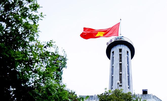 Nhiều đoàn người mặt áo cờ đỏ sao vàng, hát quốc ca dưới chân cột cờ, dâng lên tình cảm yêu nước vô hạn.