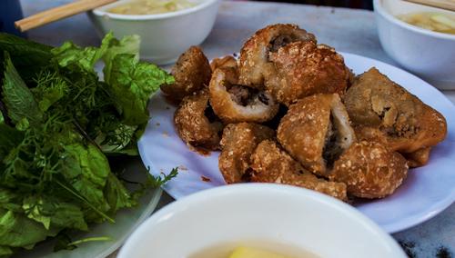 Bánh rán và bánh gối  Thực khách sành ăn ở Hà Nội đã quen với bánh gối số 52 Lý Quốc Sư, nhưng món bánh rán ở đây cũng hấp dẫn không kém. Bánh rán to và có màu vàng đặc trưng. Thực khách vừa gọi, chủ quán nhanh tay cho bánh vào chảo nóng ngập dầu. Bánh vừa chín tới sẽ được vớt ra cho ráo mỡ; khi ăn không bị ngấy. Bánh gối có lớp vỏ giòn tan, được cắt miếng vừa ăn. Nhân bánh chín tới, không bị nát quá và vẫn giữ được hương vị của nấm hương, mộc nhĩ. Đi kèm với đĩa bánh nóng hổi là bát nước chấm đu đủ xanh thanh nhẹ và rau sống.Giá cả là 7.000 đồng/ chiếc bánh rán và 9.000 đồng/ chiếc bánh gối. Ảnh: Minh Đức.