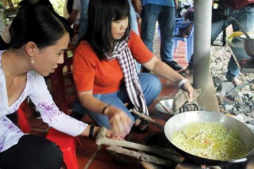 Thiếu nữ địa phương hướng dẫn du khách đổ bánh xèo.