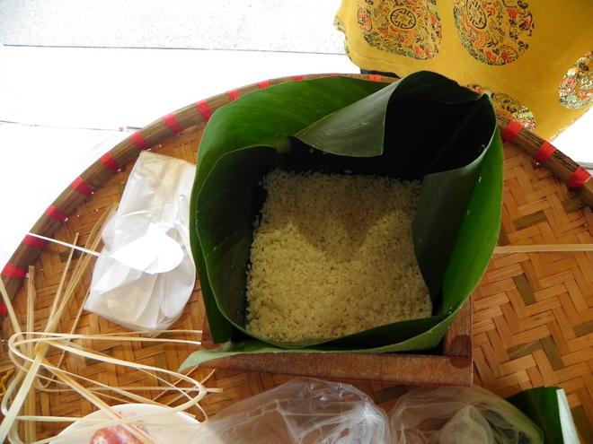 Sau khi lá được xếp gọn gàng, đổ gạo nếp vào, dùng tay ấn cho đều, tiếp đến là đậu xanh, rồi thịt nạc và một lớp đậu xanh khác. Cuối cùng kết thúc bằng chén gạo nếp thứ hai.