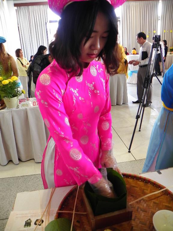 Nữ sinh viên Hàn Quốc này đến Việt Nam 6 tuần và đây là lần đầu tiên cô gói bánh chưng. Khó khăn của cô là công đoạn xếp lá tạo khuôn.