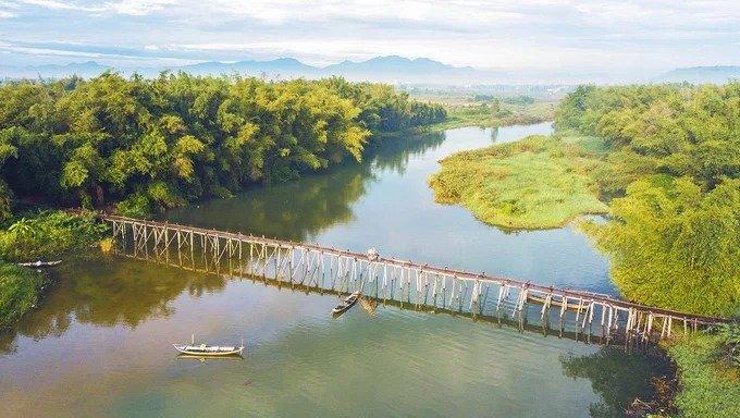 Cầu tre dẫn vào xóm Lân, bắc qua dòng sông Trà Khúc thuộc địa phận xã Tịnh Long, TP Quảng Ngãi. Cây cầu dài khoảng 200 m này sẽ được người dân trong xóm tháo dỡ khi mùa lũ về và chờ đến mùa nắng mới dựng lại. “Cảnh nông thôn tĩnh lặng bên cầu tre xóm Lân đẹp như bức tranh thủy mặc. Đây là địa điểm thu hút nhiều nhiếp ảnh gia đến sáng tác. Nhiều bạn trẻ không thích xô bồ thành phố cũng tìm về vùng quê này để hít thở không khí trong lành”, anh Đoàn Vương Quốc, tác giả bộ ảnh chia sẻ.