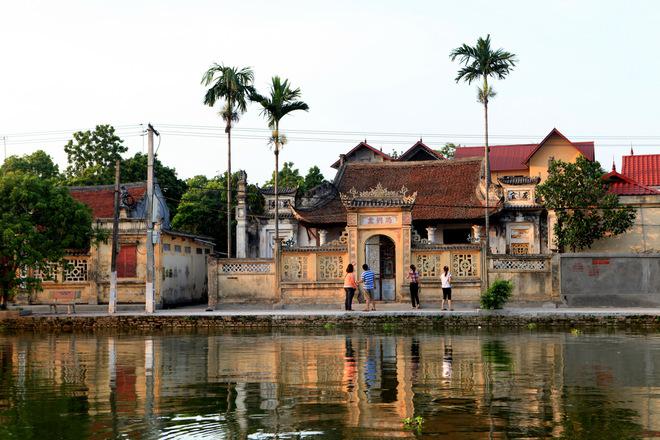 Hai bên hồ là những cây cau thẳng tắp trước các ngôi nhà cổ, nhà thờ họ với nét kiến trúc cổ xưa in hình dưới mặt nước.