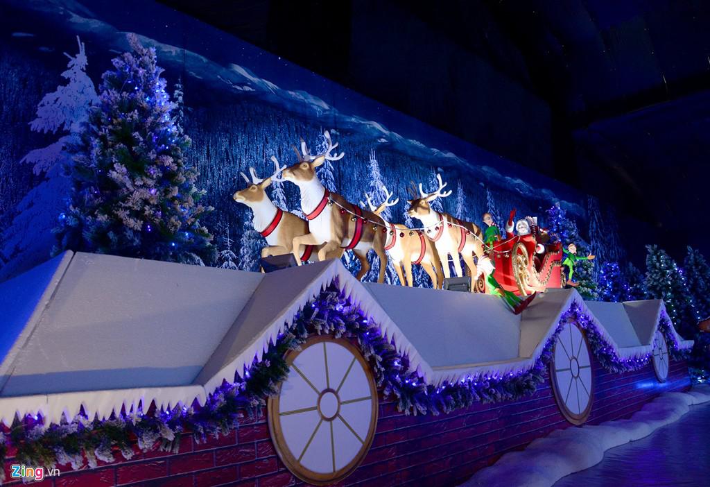 Mô hình đàn tuần lộc kéo xe chở ông già Noel băng qua mái nhà.