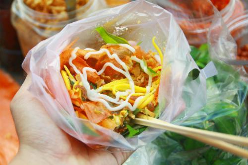 Bên cạnh đó, những hàng bánh tráng ở đây cũng có thêm loại bánh tráng cuốn. Món ăn này đặc trưng với vị bùi của trứng cút, đậu phộng, vị béo từ chà bông, bơ, hành phi. Khi ăn, thực khách sẽ trộn cùng một ít vị chua của nước sốt me và xoài xanh. Gia vị này khiến món ăn thêm vừa miệng và không bị ngán.