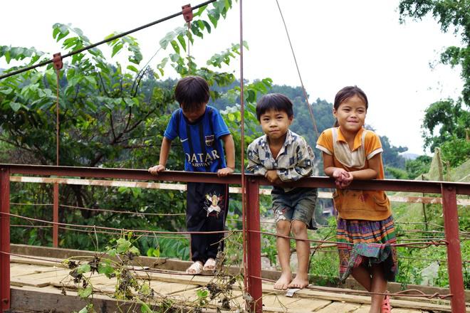 Những đứa trẻ Phình Hồ chơi đùa bên cây cầu bắc qua suối. Trẻ em dân tộc ở đây không đòi kẹo, xin tiền khách du lịch, khi được khách cho quà đều biết nói lời cảm ơn.