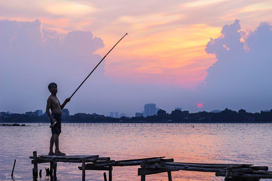 Một người đàn ông đang buông cần trên Hồ Tây.