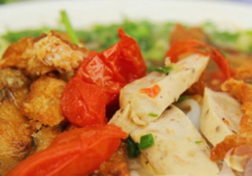 Bát bún cá được dọn là một bức tranh hài hòa màu sắc với màu trắng của bún, vàng của cá, đỏ của cà chua và xanh của hành, thì là. Ảnh: giadinh