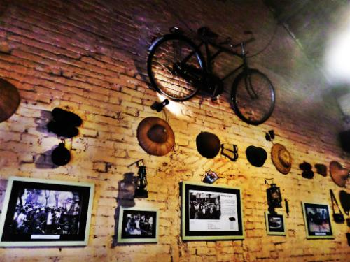 Trên tường treo nhiều đồ vật, tranh ảnh cổ.