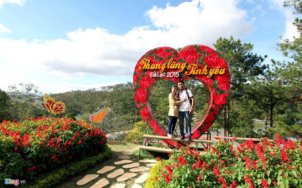 Đôi bạn trẻ tranh thủ ghi hình lưu niệm tại vườn hoa có hình tượng biểu trưng cho tình yêu.