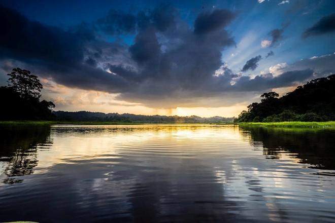 Hoàng hôn trên Bàu Sấu. Ánh mặt trời hừng lên từ đám mây đen ở rặng núi phía xa.