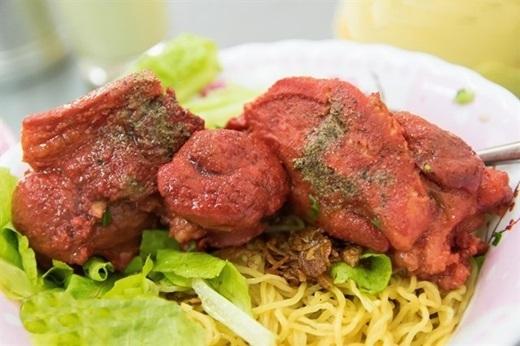 Màu đỏ bắt mắt từ thịt giò heo hoàn toàn là do loại chao đỏ đặc biệt của người Hoa – một thứ gia vị được dùng để làm thịt thêm đậm đà. Mì vàng tươi dai dai làm nổi bật lên giò heo đỏ, húp một ít nước lèo ngọt tự nhiên và ngon khó cưỡng, một tô mì giò heo đỏ thật nóng chính là thứ bạn cần để tiếp năng lượng cho ngày làm việc đầu tuần. (Ảnh: Internet)