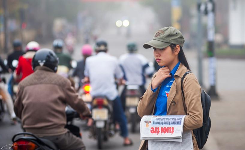 Cô bé sinh viên bán báo trong buổi sáng mờ sương.